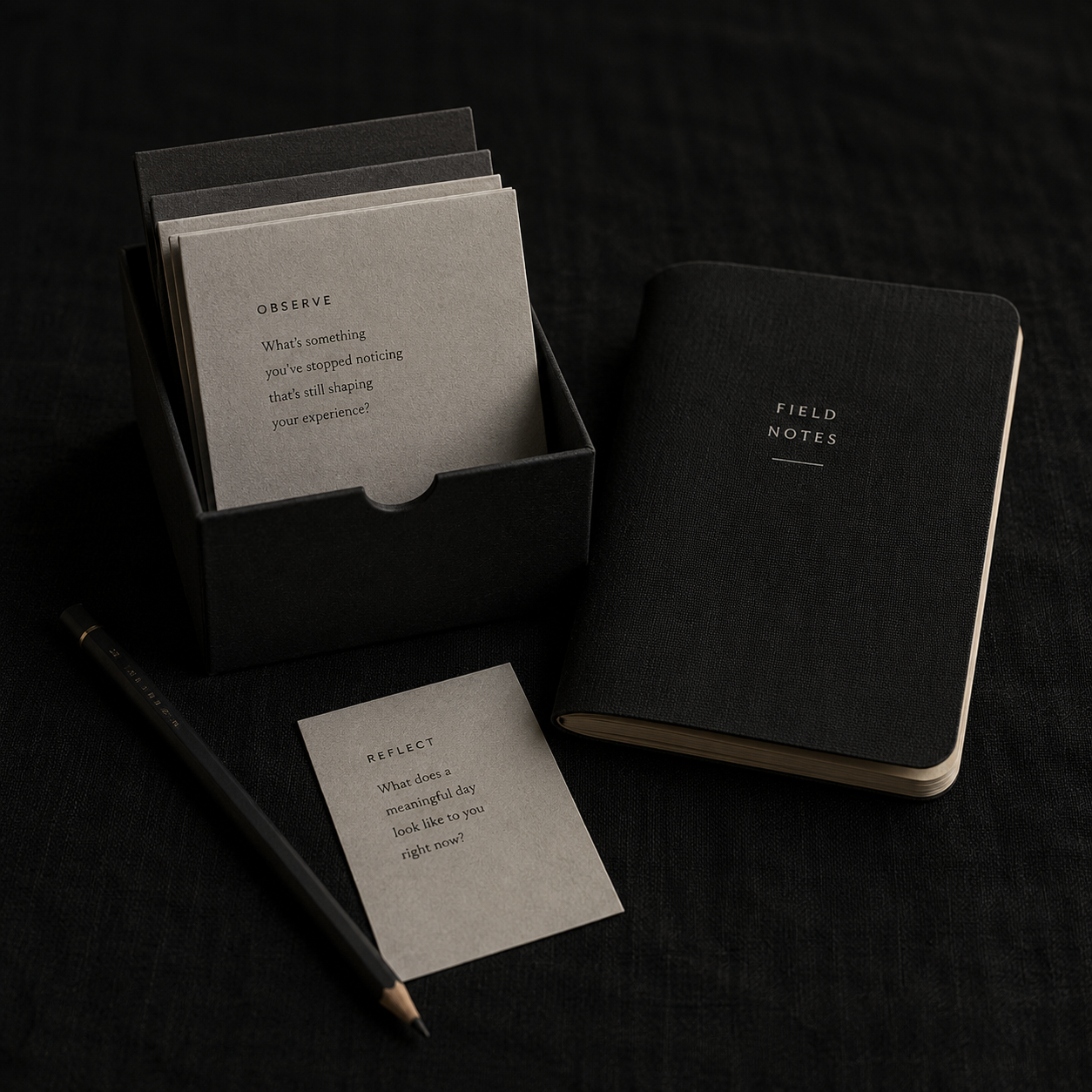 Gesture cards, folded notes, and a pocket notebook on dark linen